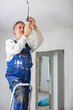© lightpoet - Senior man installing a bulb in a freshly renovated appartment
