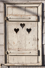 Wall Mural - Heart shape look out on wooden door to outhouse.