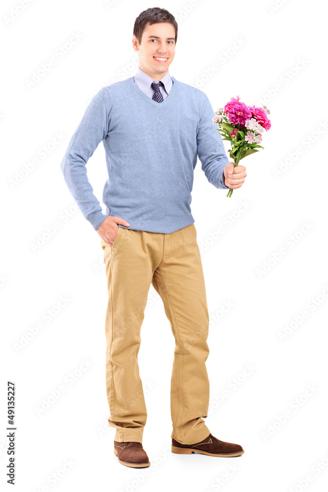 Full length portrait of a young romantic man holding a bouquet o
