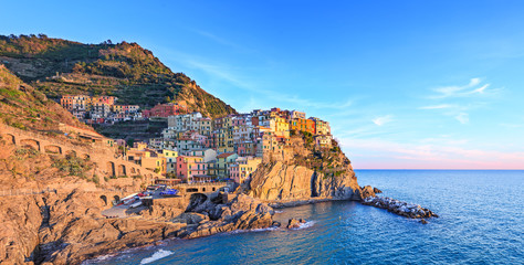 Manarola village, rocks and sea at sunset. Cinque Terre, Italy