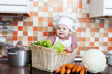 child sits in a wattled basket on a table with vegetables