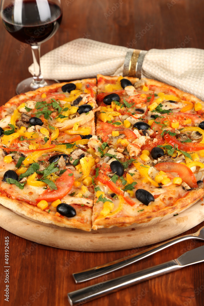 Tasty pizza with wine on wooden table close-up