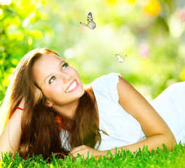 Spring Beauty. Beautiful Girl Lying on Green Grass outdoor