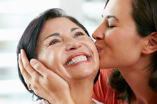 Portrait Of Adult Daughter Kissing Mother