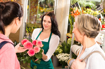 Wall Mural - Happy florist woman showing roses flowers customers