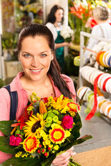 Wall Mural - Smiling young florist woman colorful bouquet shop