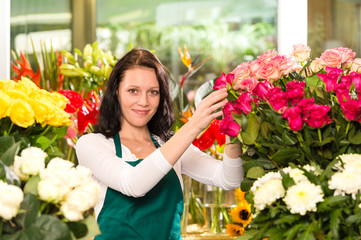 Wall Mural - Happy young woman arranging flowers florist shop