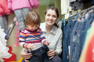 Poster - mother with baby chooses jeans