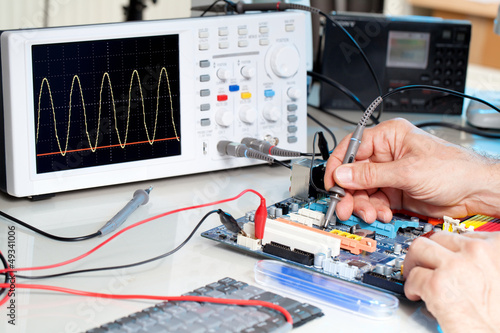 Fotografie, Obraz Tech tests electronic equipment in service centre.