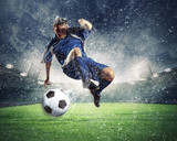 Fototapeta Młodzieżowe - football player striking the ball