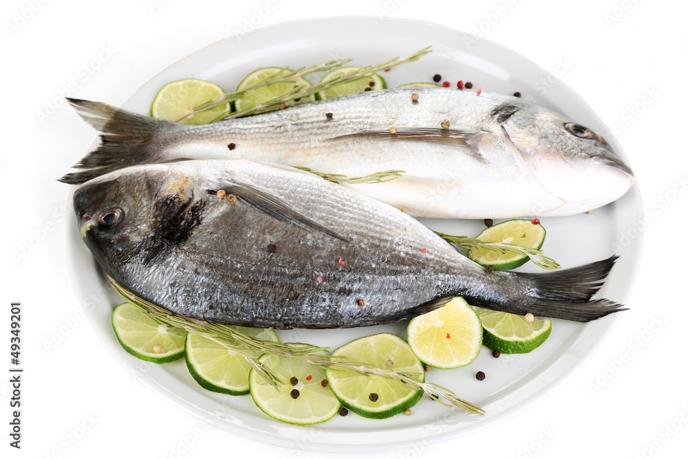 Two fish dorado with lemon on plate isolated on white