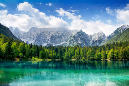 Türkisfarbener See mit Wald und Bergen