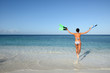 Joyful woman in bikini runs to the sea