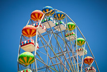 Close-up Of Colorful Ferris Wheel On Vivid Blue Sky