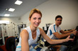 © goodluz - People exercising on bicycles in fitness gym