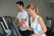 © goodluz - Couple in fitness gym using running belt