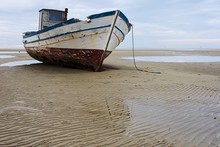 Stranded Fishing Boat After A Storm On The Beach At Grado, Italy