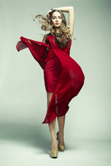 Fashion photo of young magnificent woman in red dress