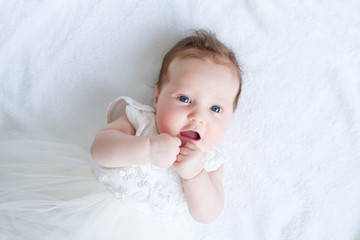 Wall Mural - Blue eyed baby girl in a white dress