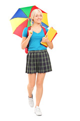 Poster - Full length portrait of a blond female student walking with umbr