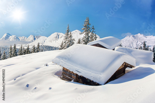 Naklejka ścienna Snow covered hut winter landscape