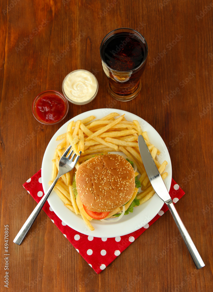 Tasty cheeseburger with fried potatoes and cold drink,