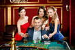 © Karramba Production - Man surrounded by women plays roulette at the casino