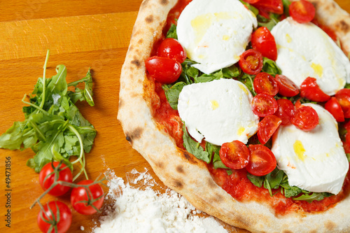 Naklejka samoprzylepna Typowa włoska pizza, składniki w tle na stół z drewna