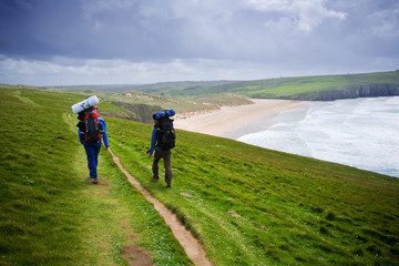 Backpackers walking Cornish Coastline