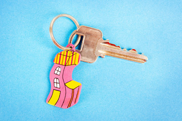 Key with funny house key ring over a blue background