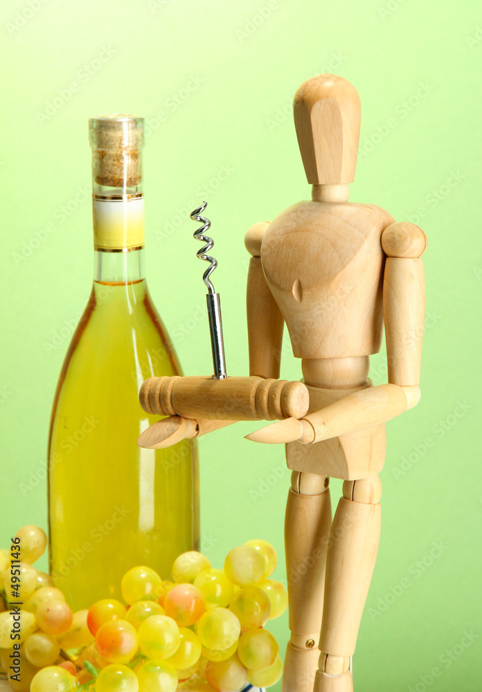 Mannequin with corkscrew and wine bottle, on green background