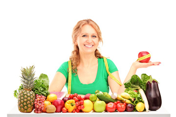 Poster - Smiling woman with fruits and vegetables holding an apple with m