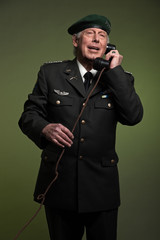 US military general wearing beret. Calling with phone. Studio po