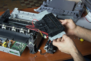 men's hands repairing laser printer