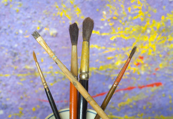 paint brushes, against wall with paint splatters