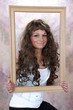 Portret brunetki z długimi włosami w ramie.