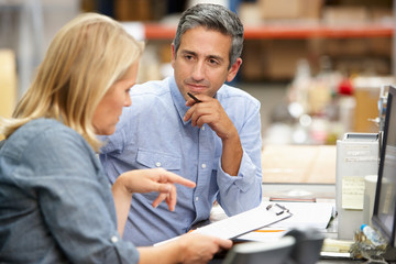 Business Colleagues Working At Desk In Warehouse