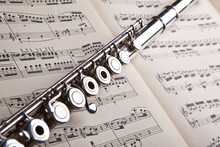 Silver Flute On An Ancient Music Score Background