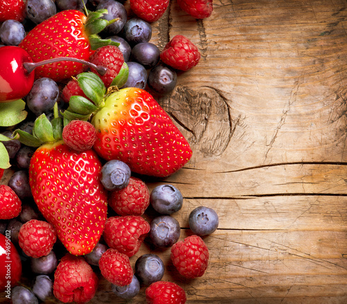 Naklejka na szybę Berries on Wooden Background. Organic Berry over Wood