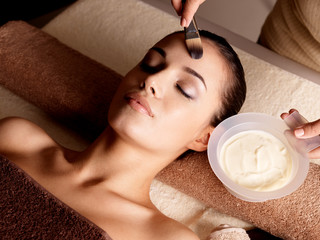 Spa therapy for woman receiving facial mask