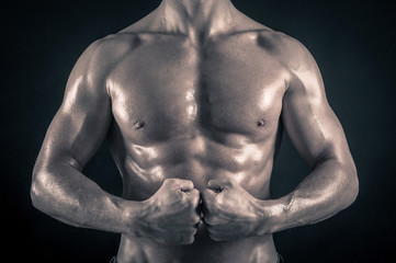 Wall Mural - Naked man torso against black background.