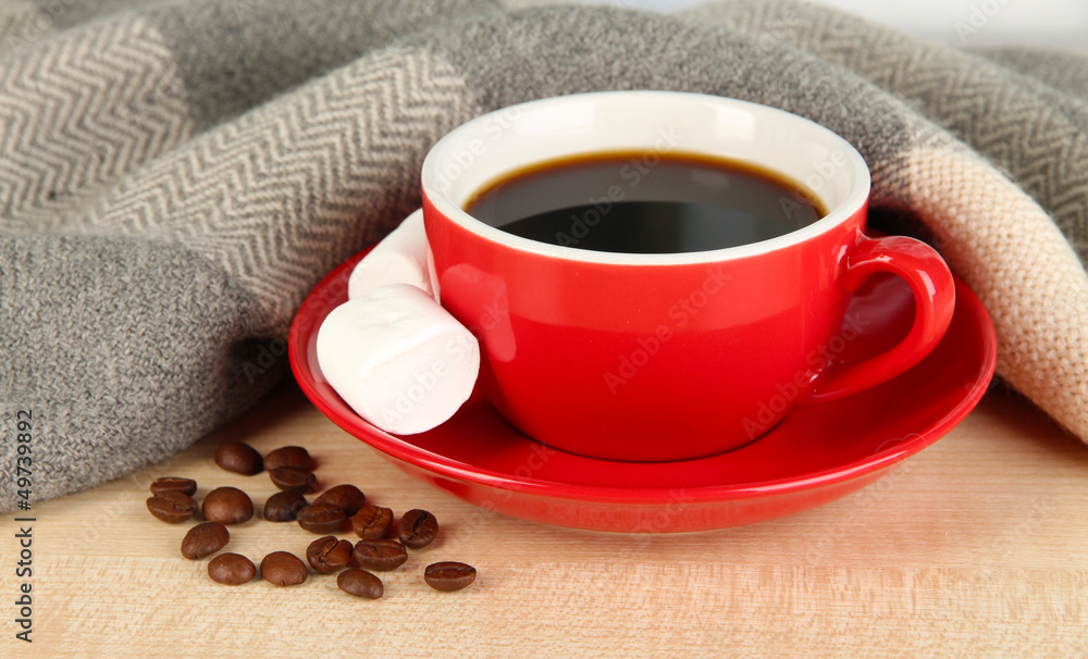 cup of coffee with scarf on table in room