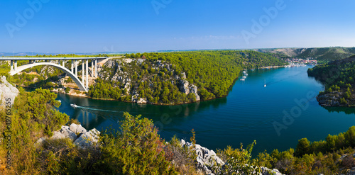 Board z aluminiowym obramowaniem Rzeka krka, most i miasto w Chorwacji