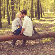 © VectorART - happy young couple kissing and hugging, sitting on a tree