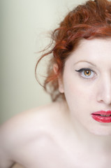 Half head portrait of girl with red hair and red lips