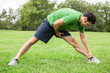 © eurobanks - Athletic man stretching legs in a field