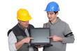 © auremar - Father and son builder team pointing at laptop