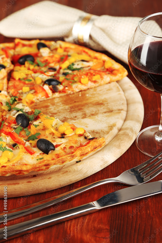 Tasty pizza with wine on wooden table close-up