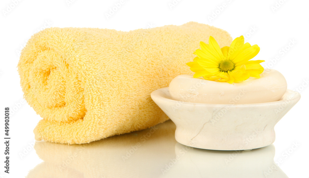 Rolled towel, soap bar and beautiful flower isolated on white
