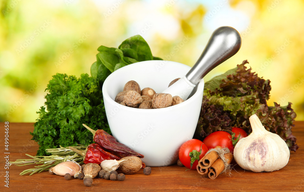 Composition of mortar,spices, tomatoes and  green herbs,